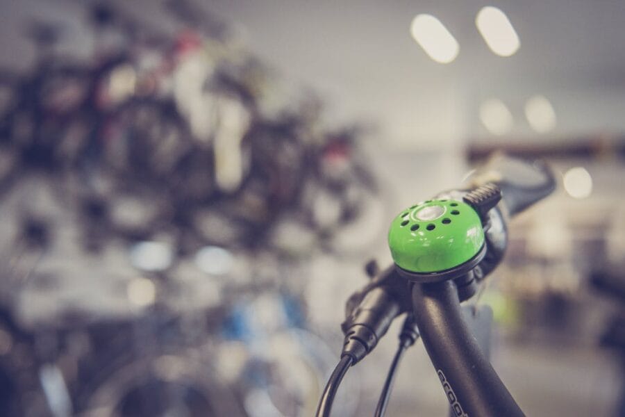 Zoom sur un guidon de vélo. Nous voyons une sonnette verte