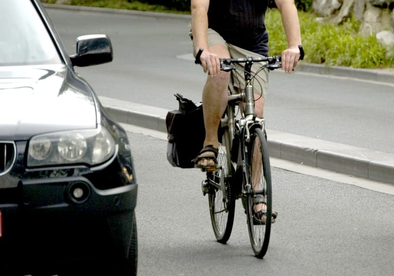 Un cycliste dépasse une voiture.