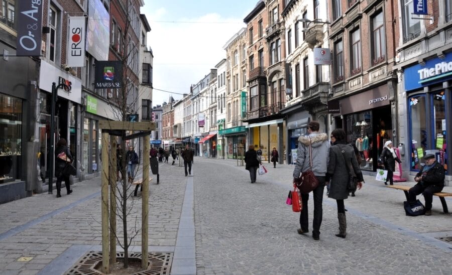 Des piétons marchent dans un piétonnier commerçant.