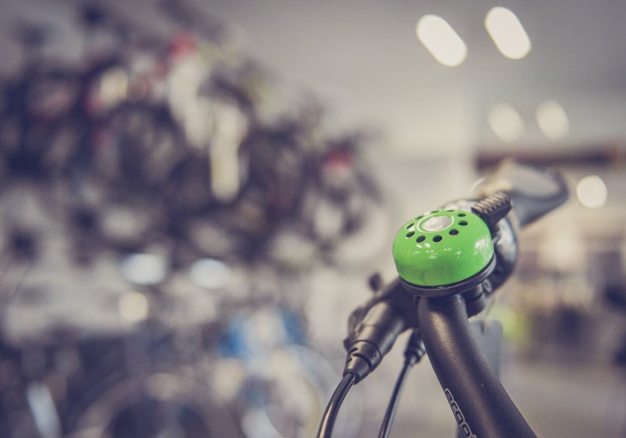 Zoom sur un guidon de vélo. Nous voyons une sonnette verte