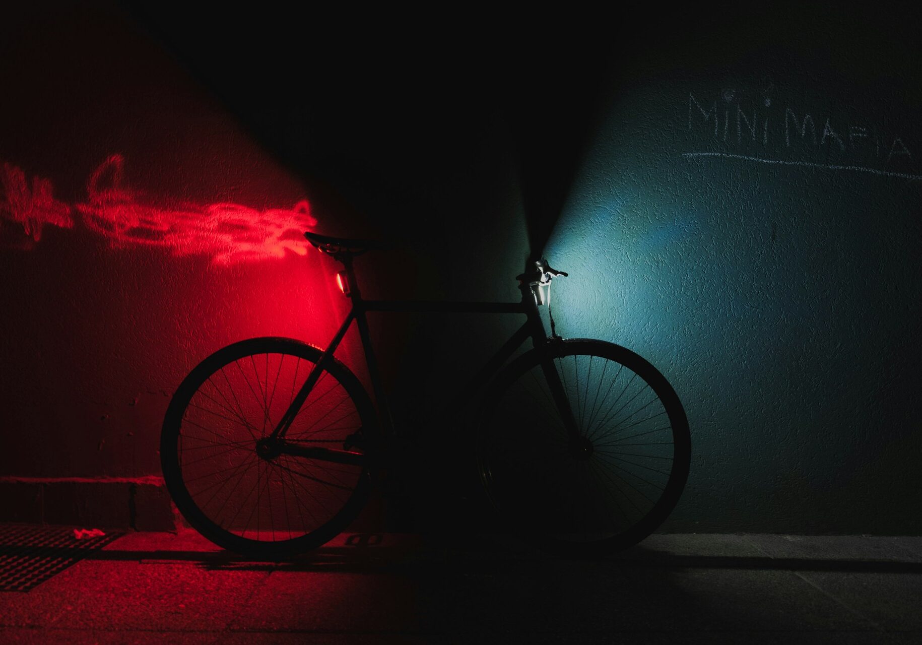 Vélo dans le noir avec un éclairage rouge à l'arrière et un éclairage blanc à l'avant